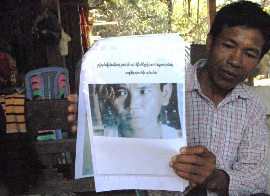 ရဲတပ်ဖွဲ့က ဆင်မုဆိုးလို့ ယူဆထားသူတစ်ဦးရဲ့ ဓာတ်ပုံကို ပြသနေတဲ့ ချောင်းစောက်ကျေးရွာအုပ်စု အုပ်ချုပ်ရေးမှူး / ထက်ခေါင်လင်း / Myanmar Now