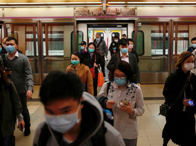 နည်းပါးလှသည့် အလုပ်သွားသူများ မျက်နှာဖုံးများ တပ်ထားသည်ကို မြင်ရစဉ်/ / Reuters 