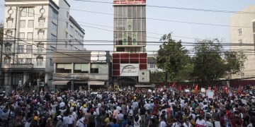 အာဏာသိမ်းပြီး ၁၅ ရက်အကြာ ရန်ကုန်မြို့ ဗဟန်းမြို့နယ် ရွှေဂုံတိုင်ရှိ NLD ရုံးချုပ်သို့ စစ်တပ်နှင့် ရဲများ ရောက်လာပြီး ရုံးတွင်းဝင်ရောက် ရှာဖွေရာ ဆန္ဒပြလူထုက ဤသို့ ပြန်လည်ဝိုင်းထားခဲ့သည် (ဧရာဝတီ)