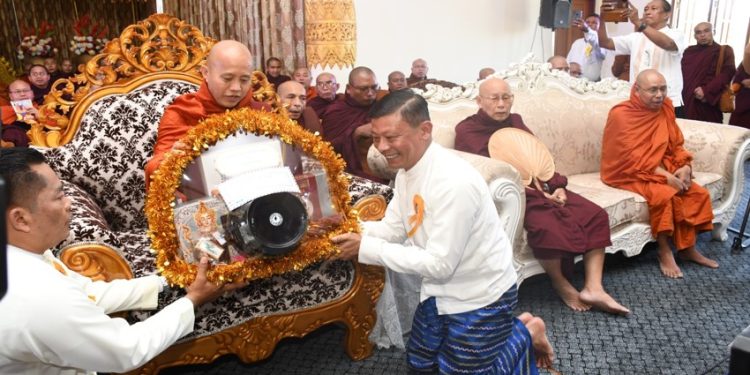 ရန်ကုန်တိုင်းလူမှုရေးဝန်ကြီး ဦးအောင်ဝင်းသိန်းက ဦးဝီရသူကို လှူဖွယ်ပစ္စည်းဆက်ကပ်စဉ်