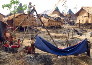 ၂၀၁၃ ခုနှစ်က မင်းလှမြို့နယ်၊ ဒဟတ်ပင်ရေနံမှော်တွင် ရေနံထွက်အောင် တွင်းတူးပြီးနောက် နောက် တတွင်း ထပ်မံတူးရန်အတွက် အမိုးအကာများကို ရွှေ့ပြောင်းရန်ပြင်ဆင်နေစဉ် / ဧရာဝတီ